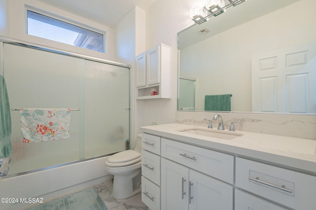 full bathroom featuring vanity, toilet, and shower / bath combination with glass door