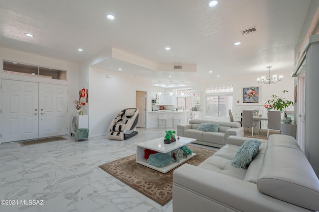 living room featuring sink, a textured ceiling, and an inviting chandelier