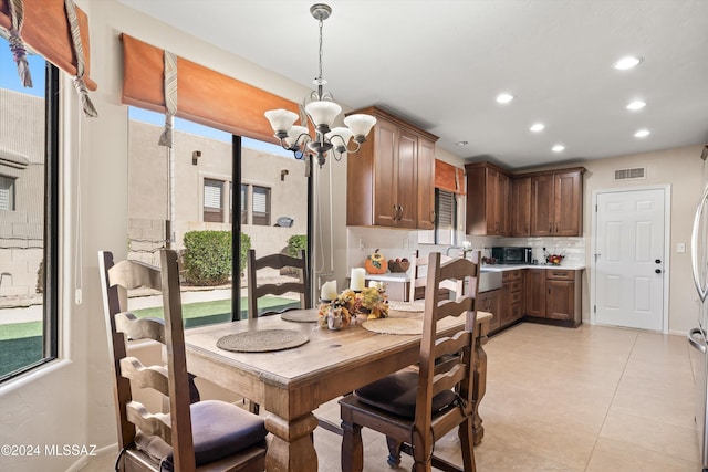 tiled dining space featuring a notable chandelier