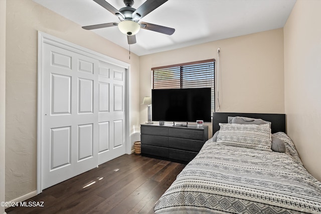 bedroom featuring ceiling fan, a closet, and dark wood-type flooring