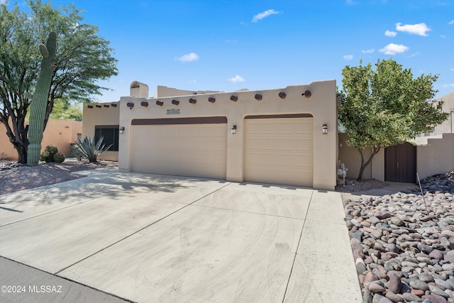 pueblo revival-style home with a garage