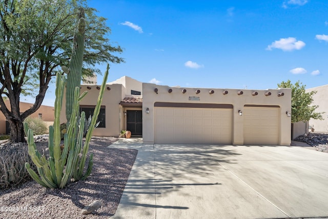 pueblo-style home featuring a garage