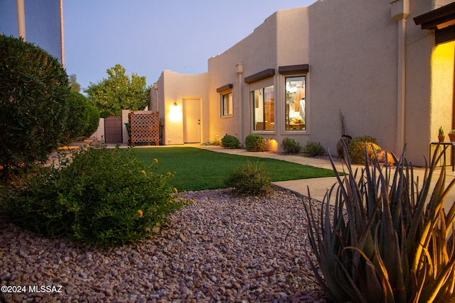 property exterior at dusk with a yard