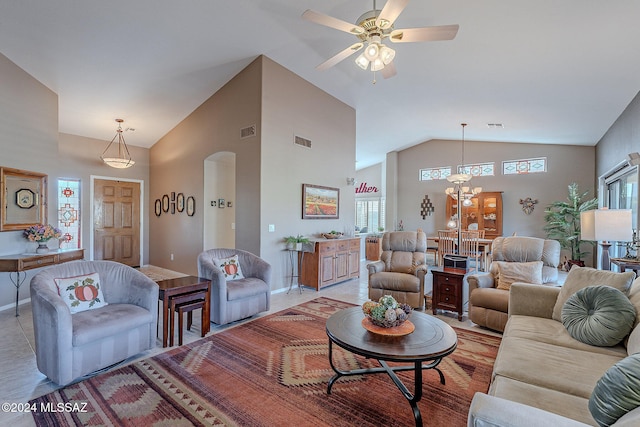 living room with ceiling fan with notable chandelier and high vaulted ceiling