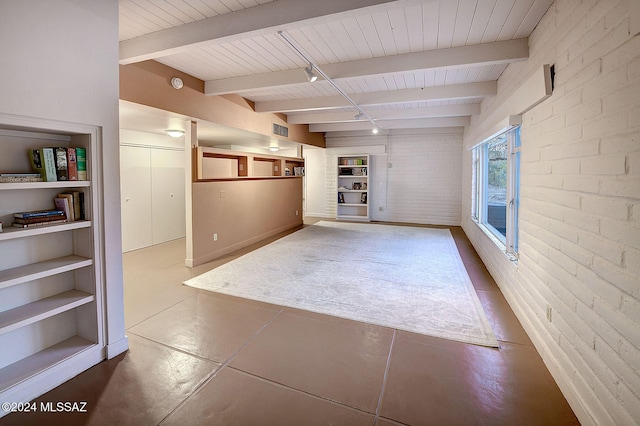 unfurnished room featuring rail lighting, brick wall, wooden ceiling, and beam ceiling