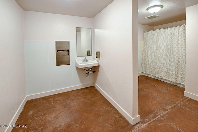 bathroom with concrete flooring and sink