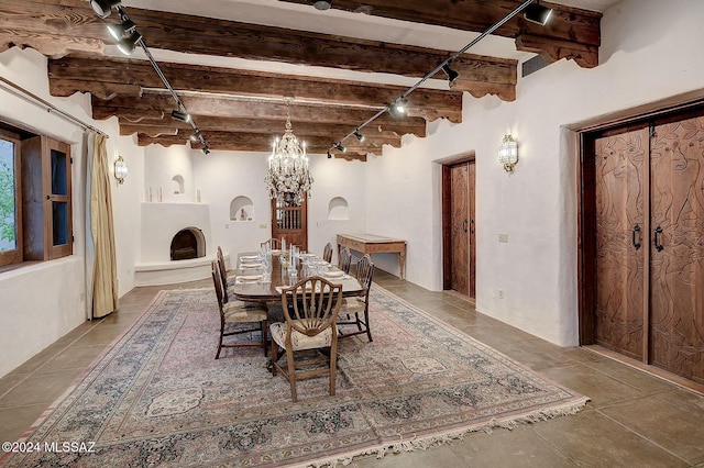 dining area with beam ceiling, rail lighting, and a notable chandelier