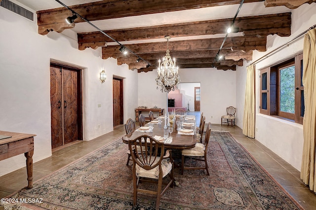 dining area featuring beamed ceiling, rail lighting, and a chandelier