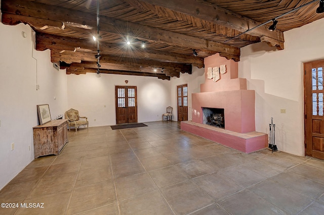 unfurnished living room with tile patterned floors, wood ceiling, and beam ceiling