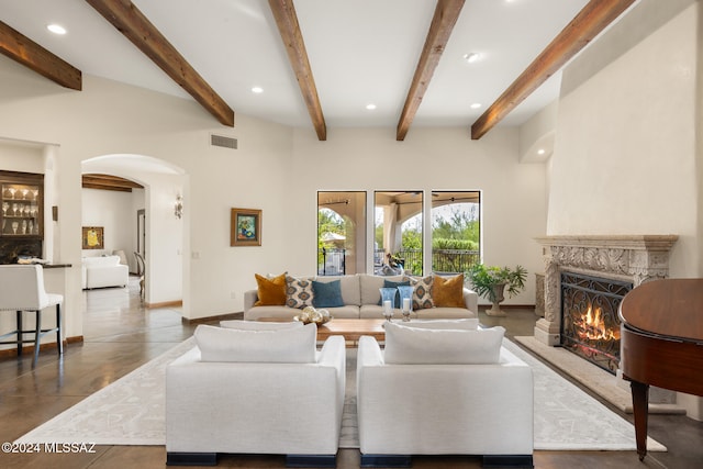 living room with a high end fireplace and lofted ceiling with beams