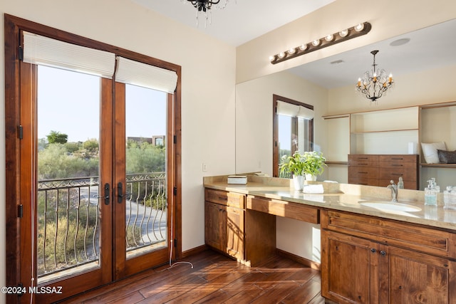 bathroom with vanity, an inviting chandelier, hardwood / wood-style floors, and french doors