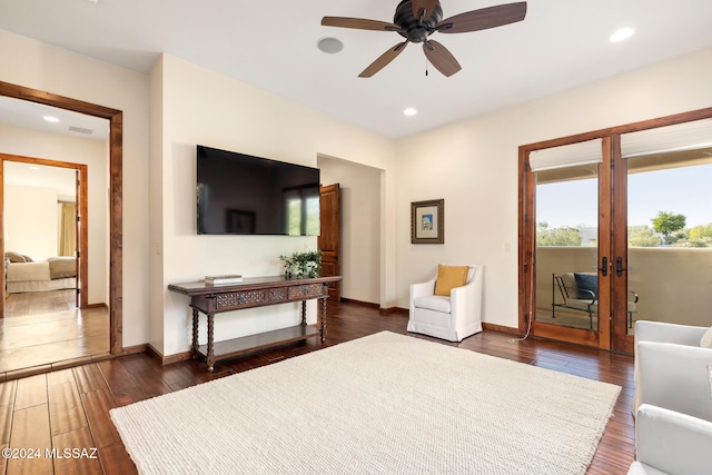 living room featuring dark wood-type flooring and ceiling fan