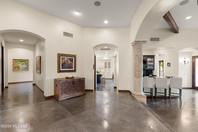 corridor with a towering ceiling and decorative columns