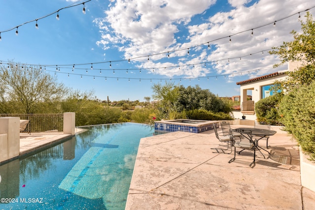 view of swimming pool with an in ground hot tub and a patio