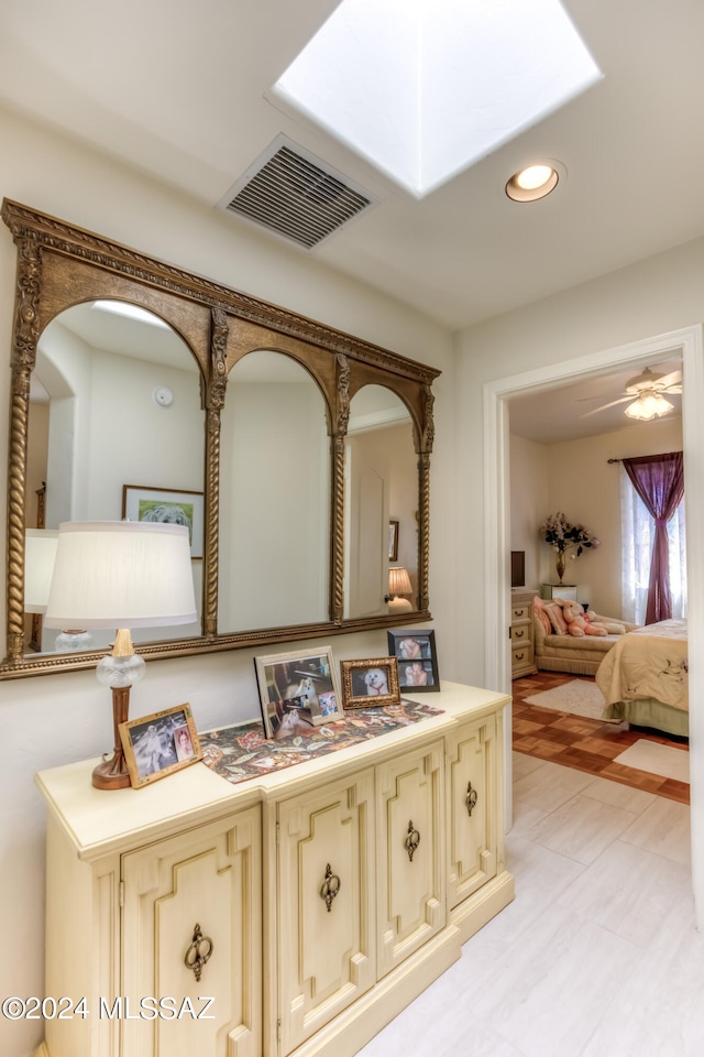 bathroom with a skylight and ceiling fan