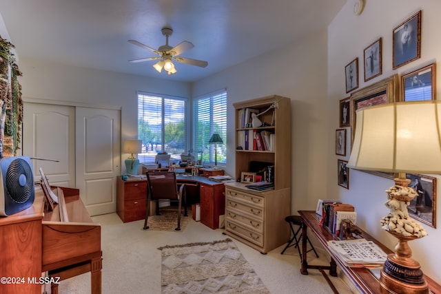 carpeted home office featuring ceiling fan