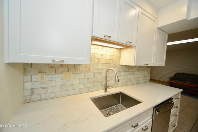 kitchen featuring white cabinets, light stone countertops, sink, and dishwasher