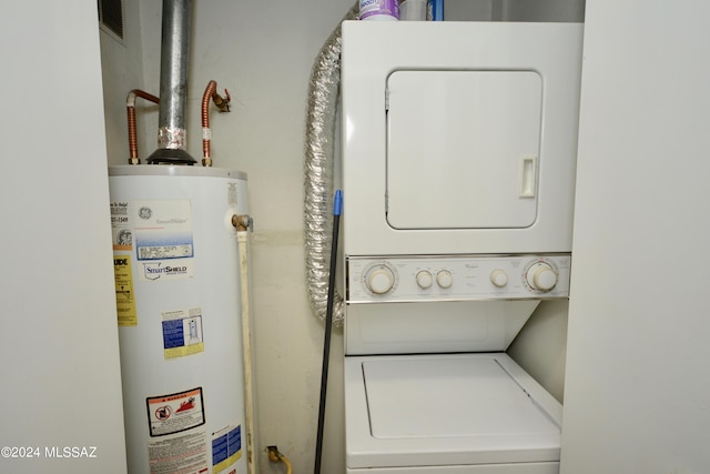 clothes washing area featuring stacked washer / dryer and gas water heater