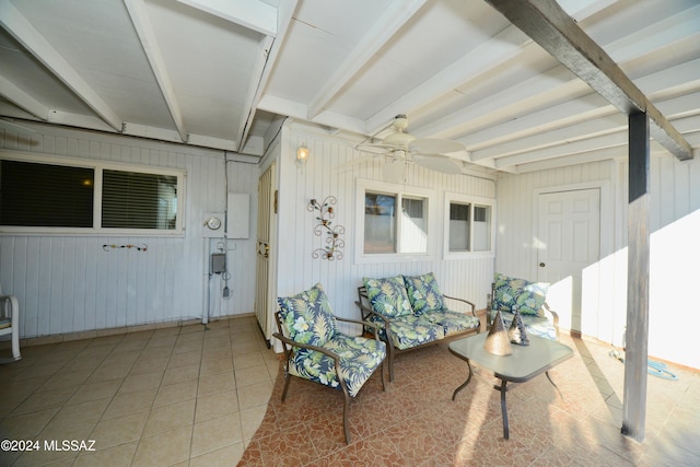 sunroom featuring beam ceiling and ceiling fan