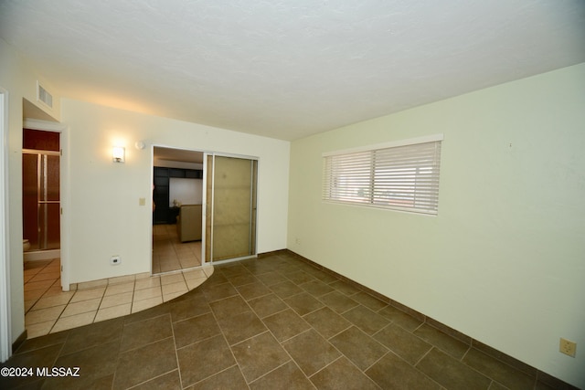 unfurnished room featuring dark tile patterned flooring