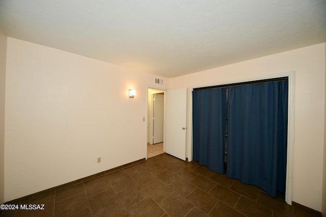 unfurnished room with dark tile patterned floors