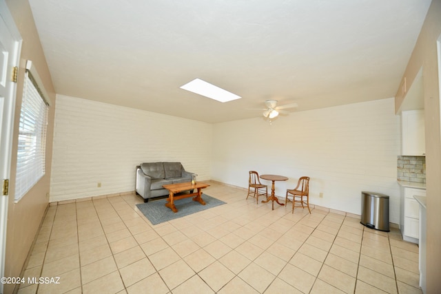 living area featuring light tile patterned floors and ceiling fan