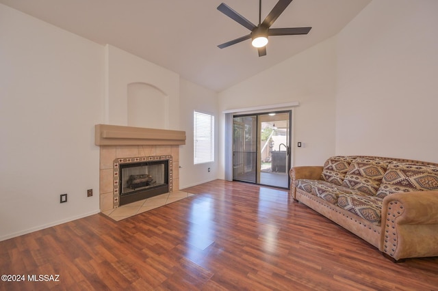 unfurnished living room featuring ceiling fan, wood-type flooring, a tiled fireplace, and high vaulted ceiling