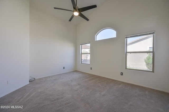 carpeted empty room featuring ceiling fan and high vaulted ceiling