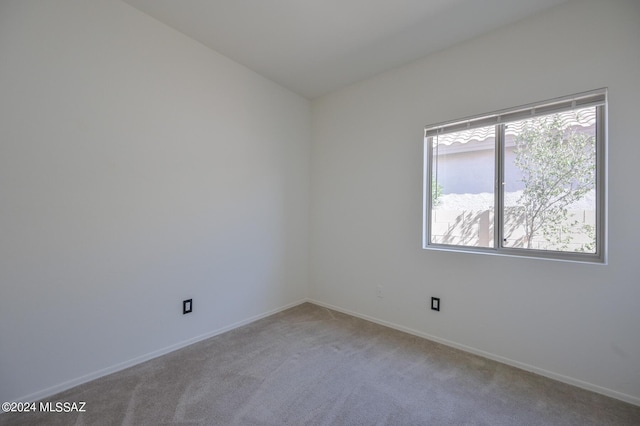 unfurnished room featuring carpet and vaulted ceiling