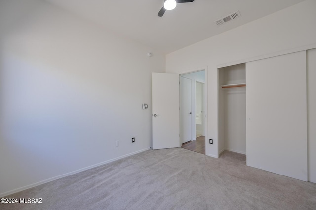 unfurnished bedroom featuring ceiling fan, a closet, and light carpet