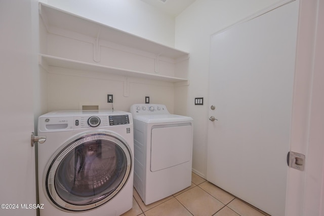 laundry room with light tile patterned floors and washing machine and dryer