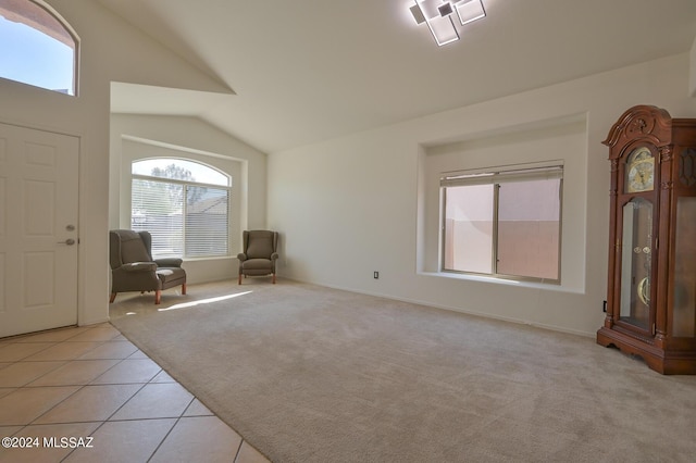 unfurnished room featuring vaulted ceiling and light colored carpet