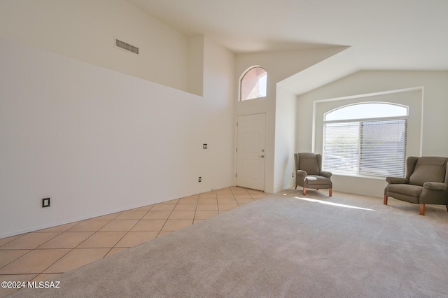 unfurnished room featuring vaulted ceiling and light tile patterned flooring