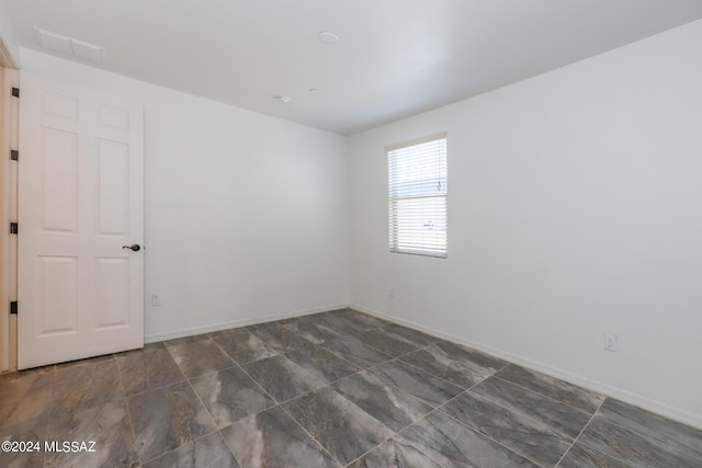 spare room with baseboards