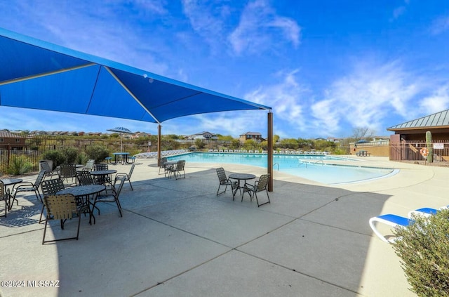 community pool with a patio area and fence