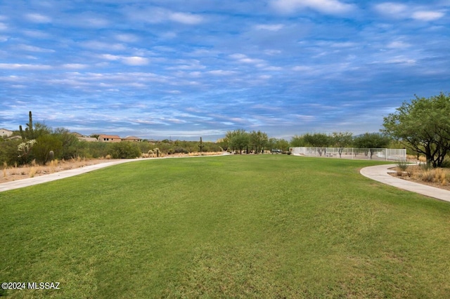 view of property's community featuring a yard and fence