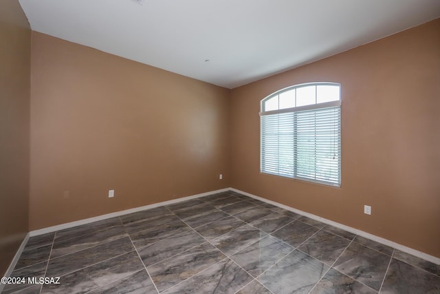 unfurnished room featuring baseboards