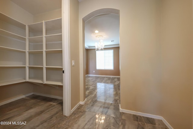 interior space featuring a chandelier, arched walkways, and baseboards