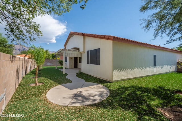 rear view of house featuring a patio and a lawn