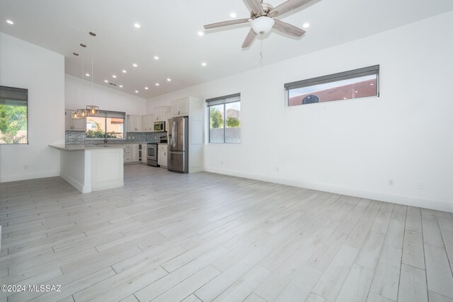 kitchen featuring plenty of natural light, hanging light fixtures, white cabinets, and appliances with stainless steel finishes