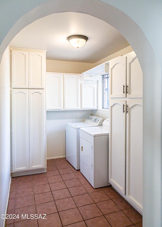 clothes washing area featuring tile patterned flooring, separate washer and dryer, and cabinets