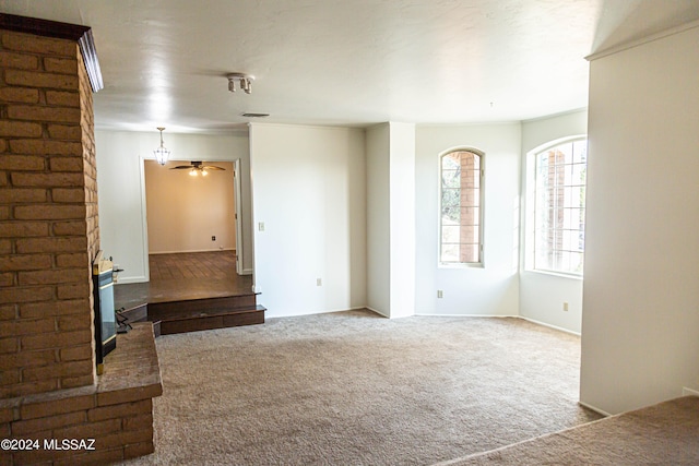 unfurnished living room with a fireplace, carpet, and ceiling fan