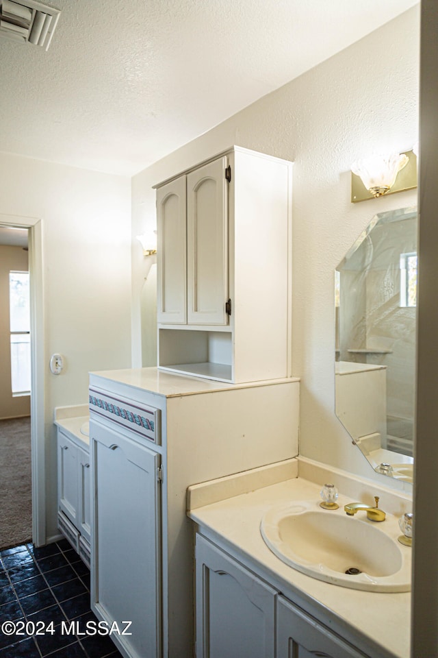 bathroom with tile patterned floors, vanity, and a textured ceiling