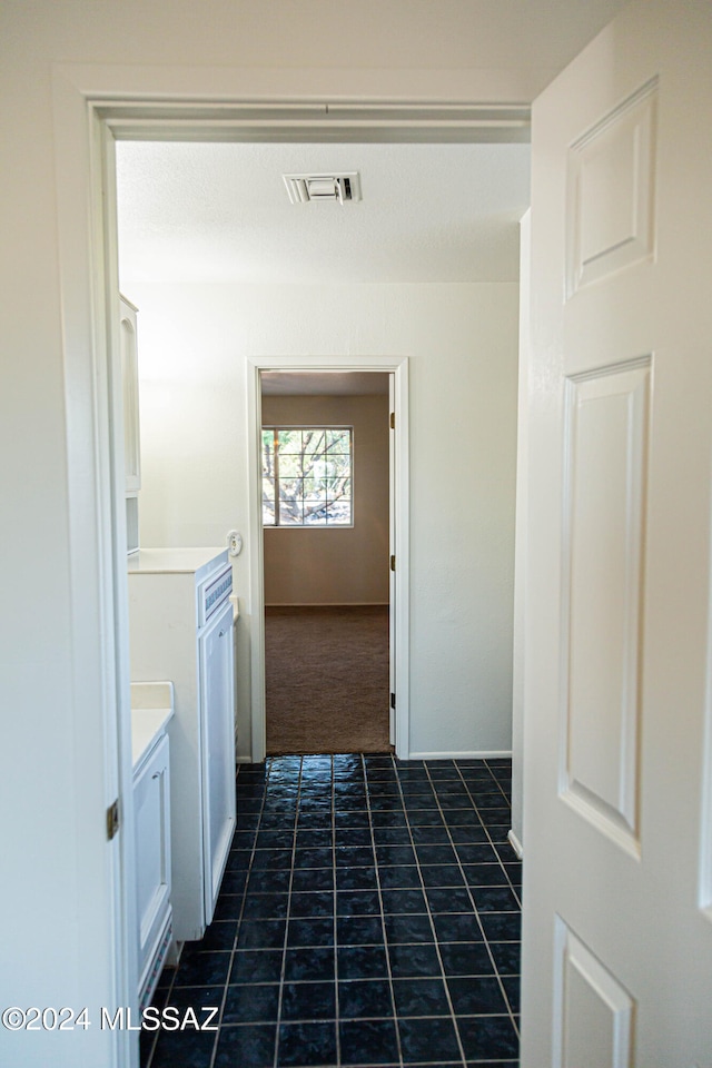 hall with dark tile patterned flooring