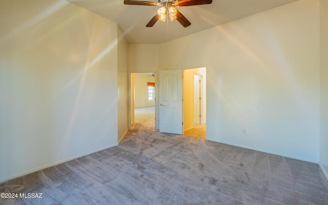 spare room featuring ceiling fan and light carpet