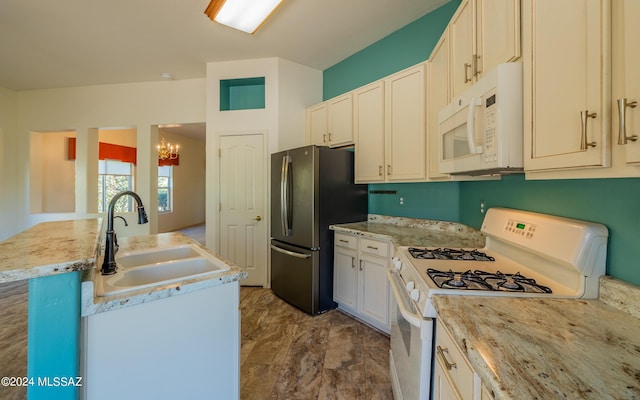 kitchen with sink, white appliances, and a chandelier