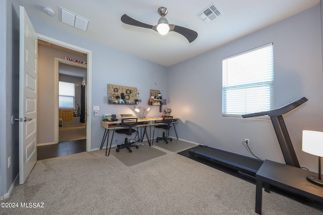 carpeted office space with ceiling fan and a healthy amount of sunlight