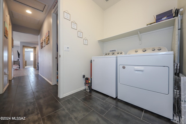 clothes washing area with washer and dryer and dark tile patterned floors