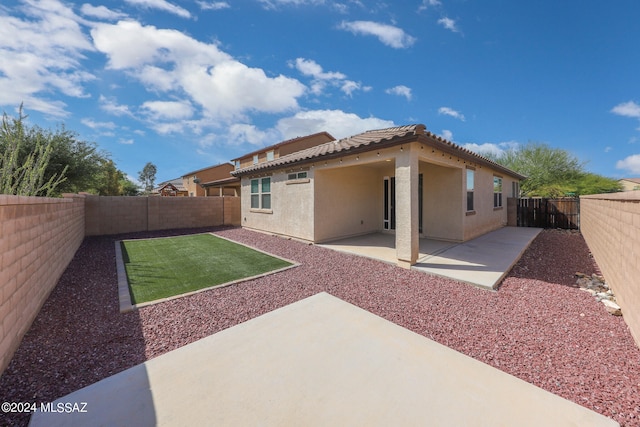 rear view of property featuring a yard and a patio area