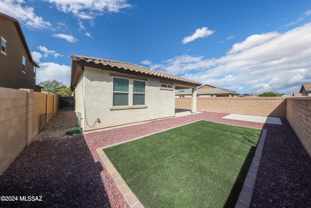 rear view of house featuring a patio area and a yard